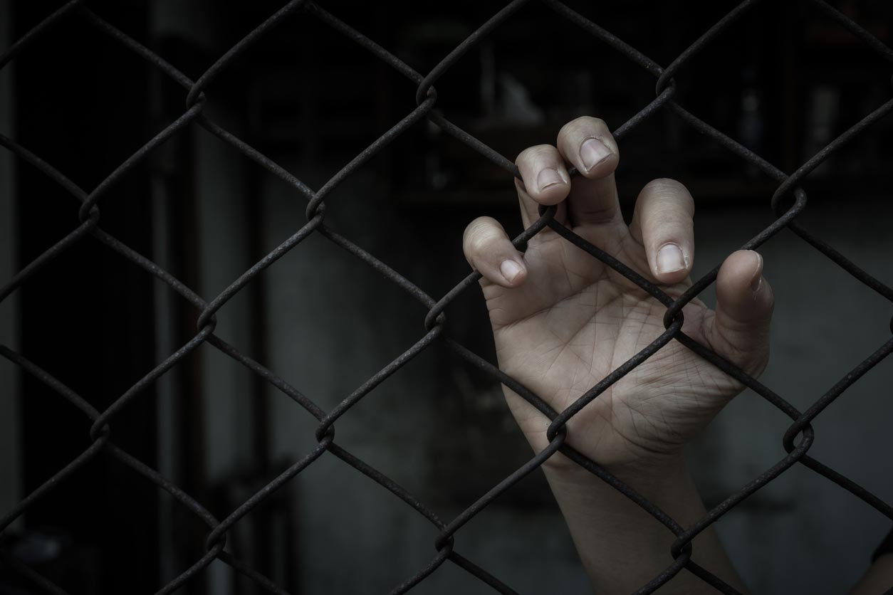 Hand grabbing a chainlink fence