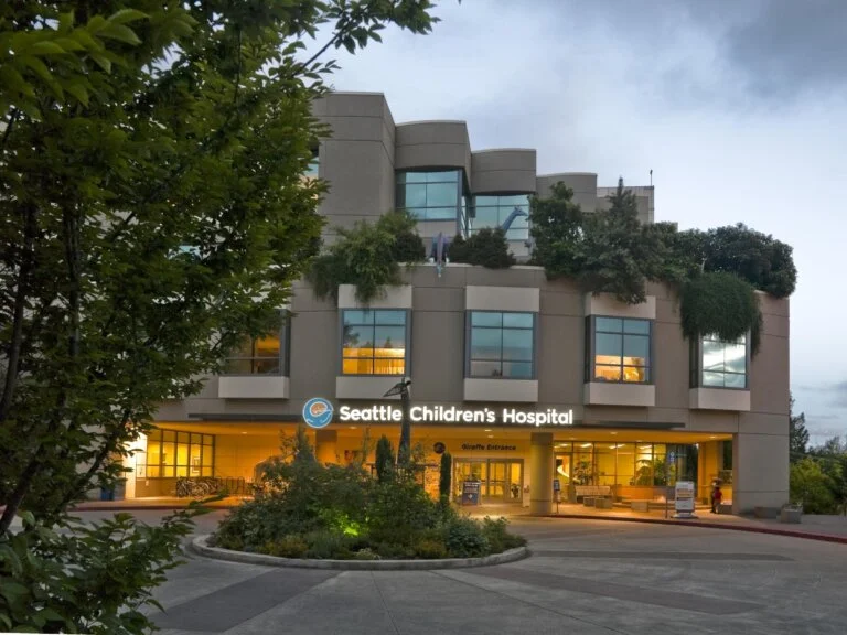 Seattle Children’s Hospital building with greenery and the Giraffe Entrance sign visible.