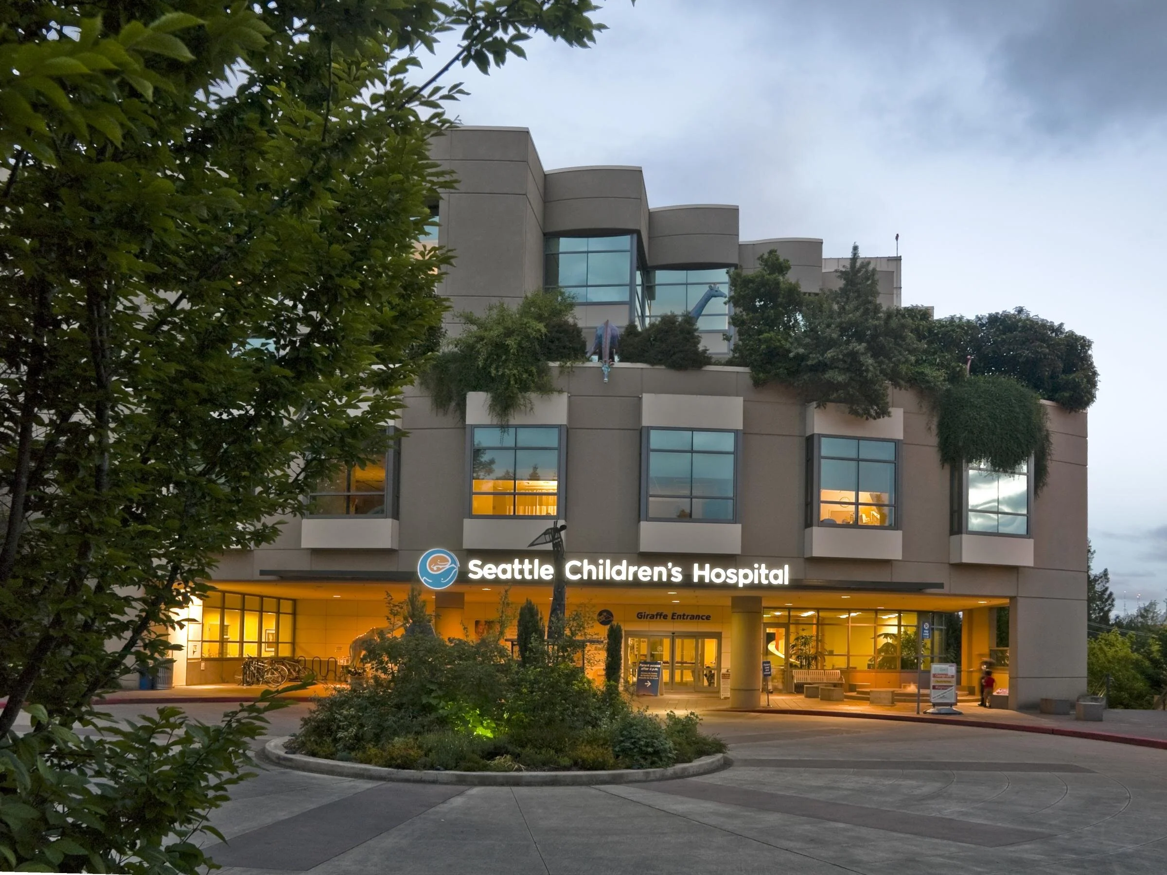 Seattle Children’s Hospital building with greenery and the Giraffe Entrance sign visible.