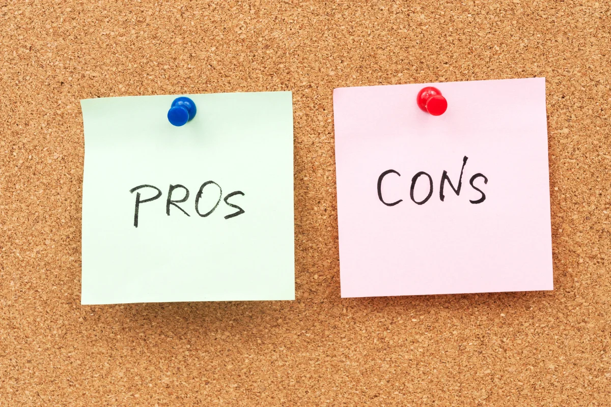 Two sticky notes pinned to a corkboard, one labeled "PROs" and the other labeled "CONs".
