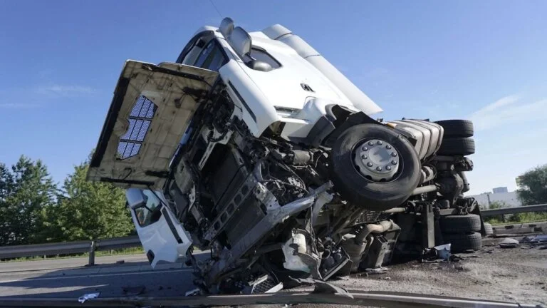 "Overturned semi-truck with severe front-end damage on a highway"