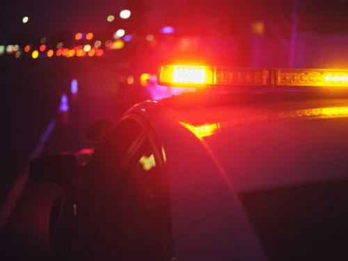 A police car stopping a vehicle at night.