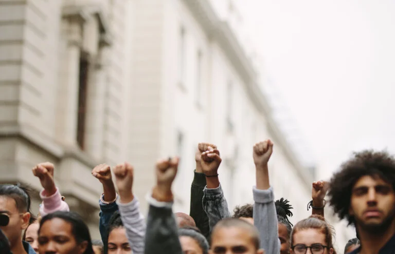 Arms raised in protest. Group of protestors fists raised up in the air.