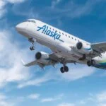 Alaska Airlines jet approaching landing with landing gear down.