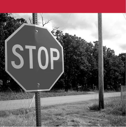 "Close-up of a stop sign near a rural road and utility pole"