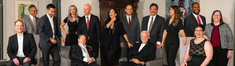 A diverse group of professionals in business attire posing for a photo in an office.