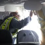 NTSB investigator examines cabin wall near missing door plug on Alaska Airlines Boeing 737 MAX 9