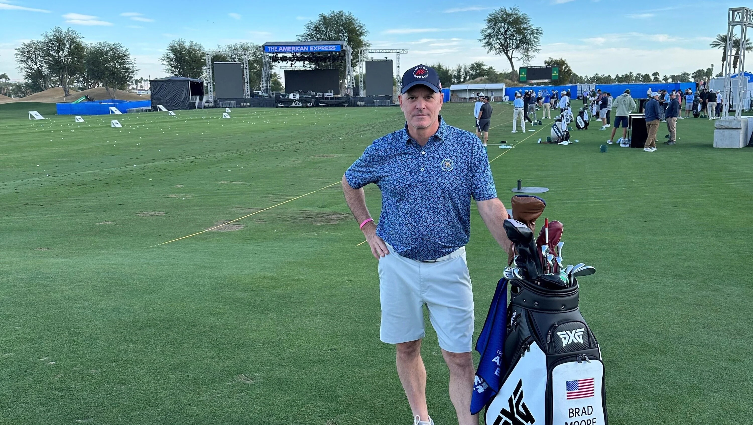 Brad Moore stands on the fairway at The American Express golf event next to a PXG golf bag with his name