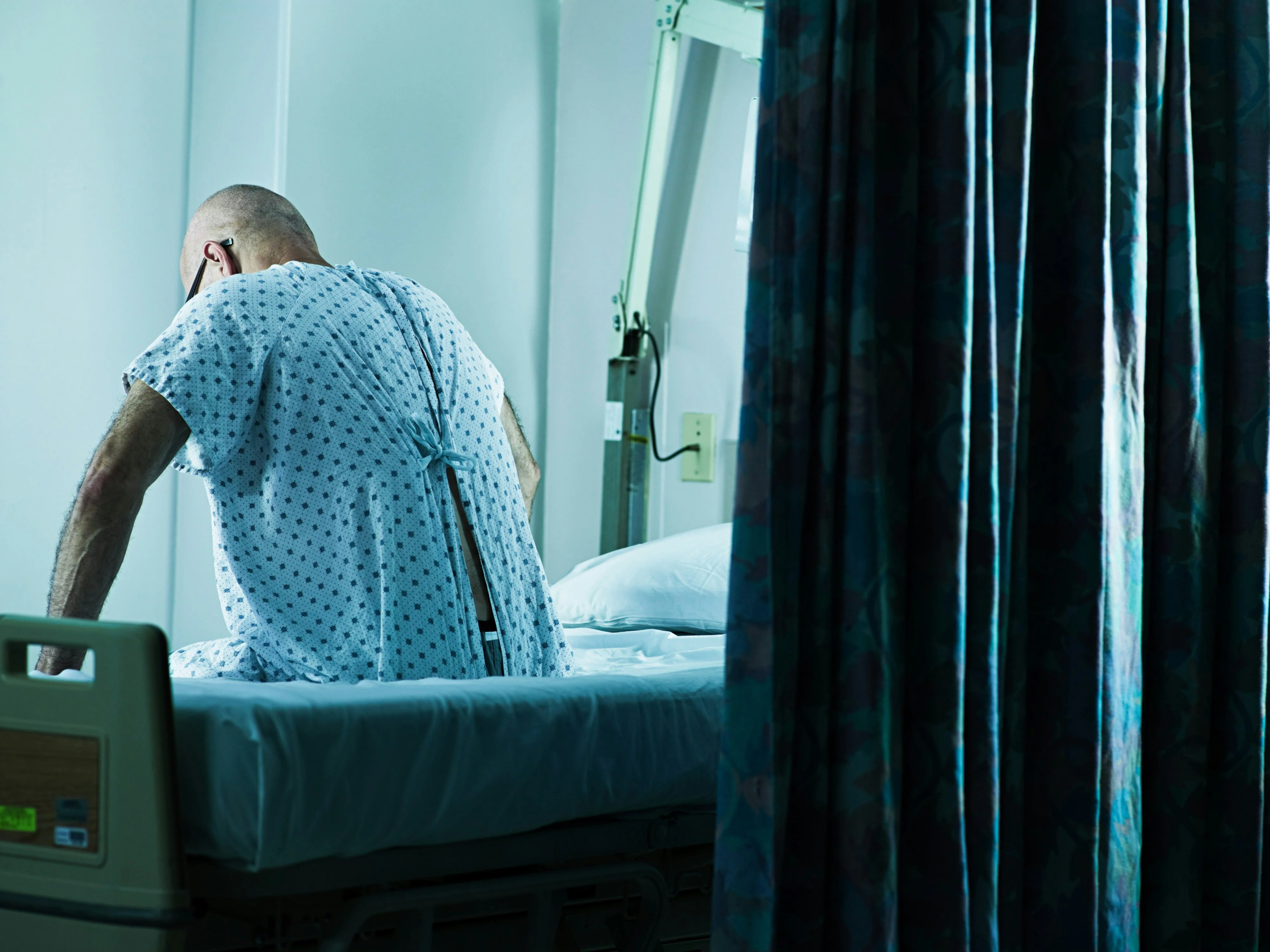 Male patient sitting in hospital bed.